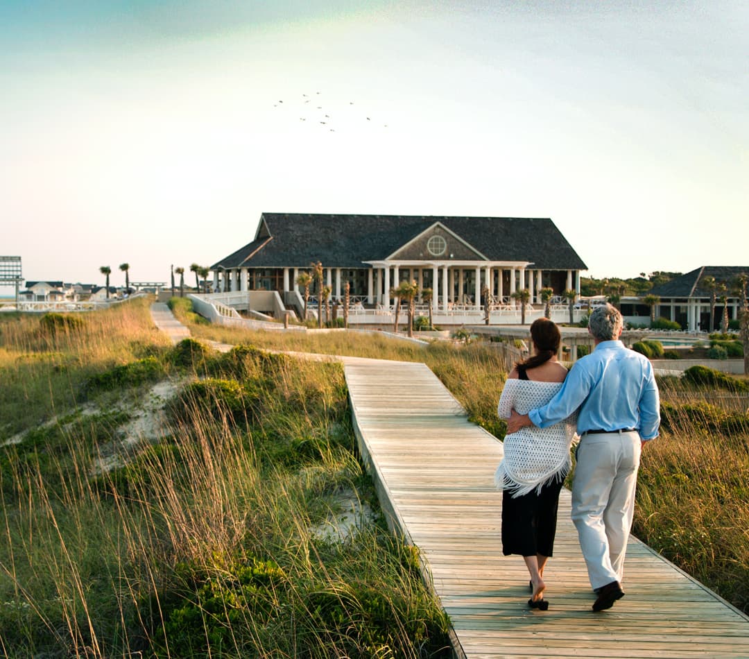 senior couple is walking towards to their luxury house