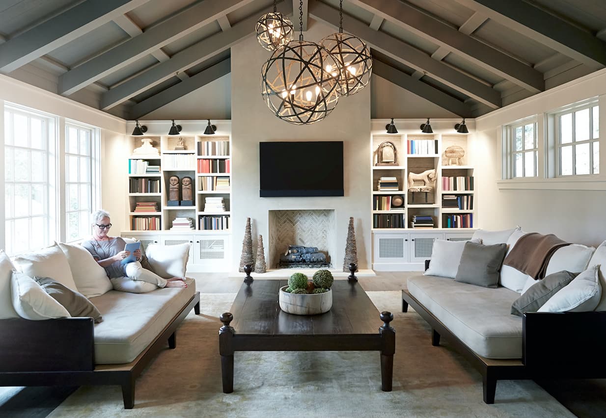 Woman reading on sofa in living room. 