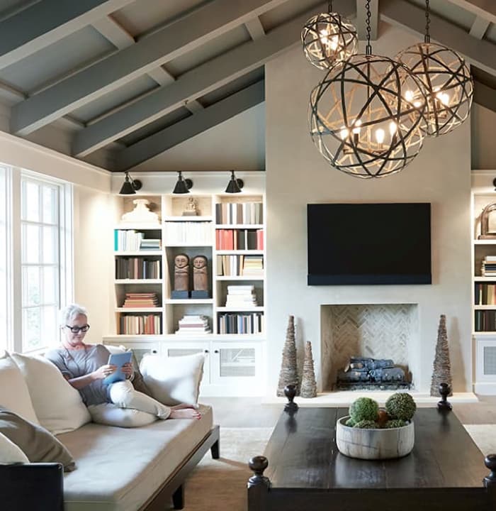 Woman reading on sofa in living room. 